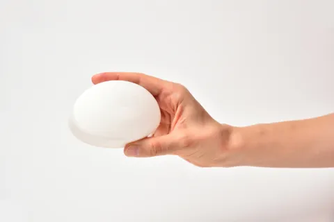 a hand holding a white ball