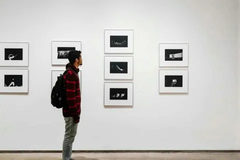 a person standing in front of a wall of pictures