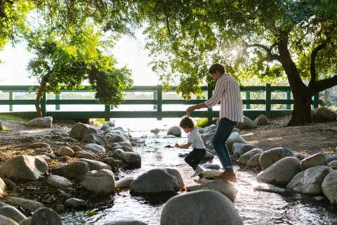 a man and a child playing in a river
