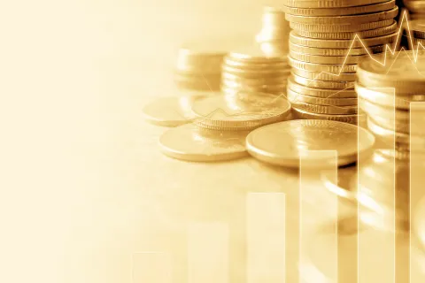 Stacks of gold coins with rising bar chart and line graph symbolizing financial growth and investment success.