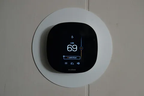 Modern smart thermostat on the wall of a Loganville, GA home, ready for spring HVAC maintenance.