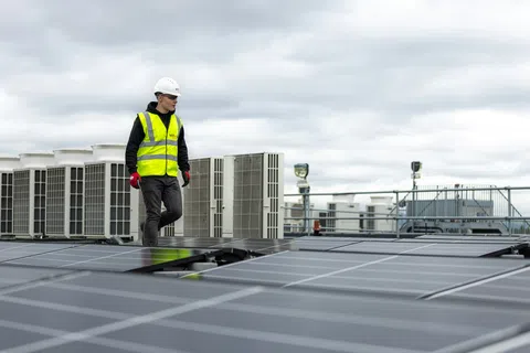 HVAC technicians in safety vests inspecting rooftop units at a Snellville GA building