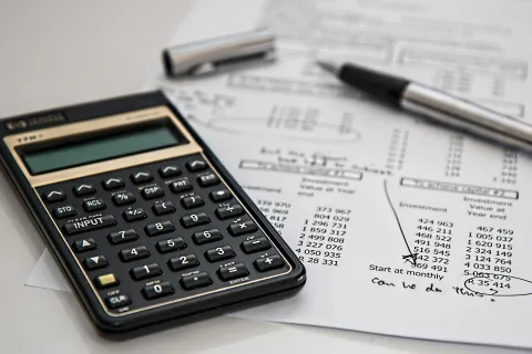 a calculator and a pen on a piece of paper