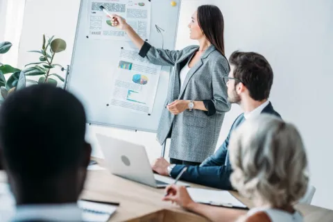 a woman presenting on a whiteboard