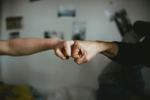 Two fists bumping together in a gesture of camaraderie and celebration.
