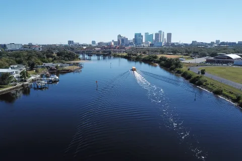 a body of water with boats in it and a city in the background