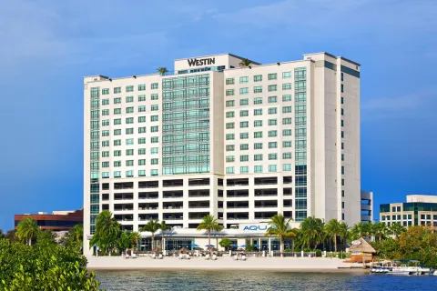 a large white building next to a body of water