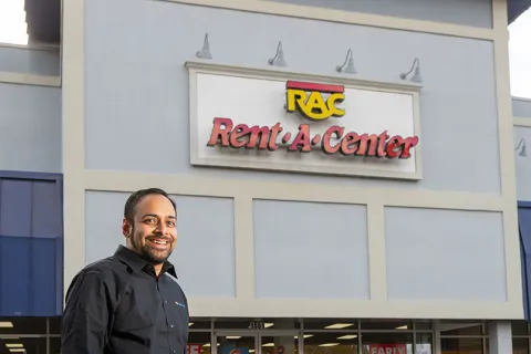 a man standing in front of a building with a sign on it