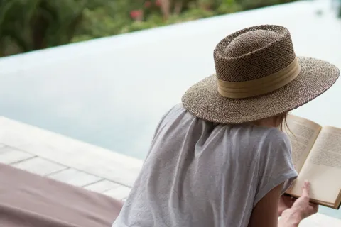 a person sitting on a bench reading a book