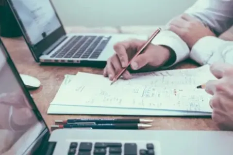 a person writing on a piece of paper