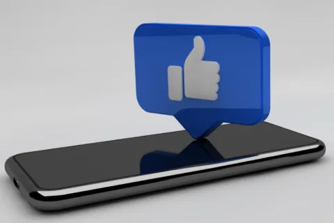 facebook like icon on top of a mobile phone