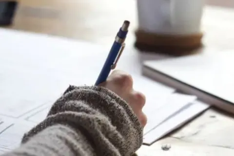 a person writing on a piece of paper