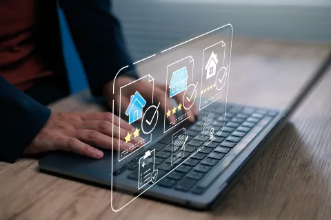 Person using laptop with holographic real estate icons showing house listings and ratings on screen.