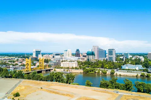 Aerial view of Sacramento skyline with Tower Bridge over the Sacramento River on a clear sunny day.