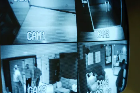 Surveillance camera footage displaying four different camera views inside a building.