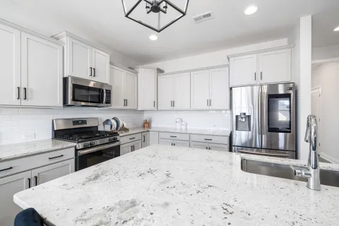 a clean kitchen with white cabinets