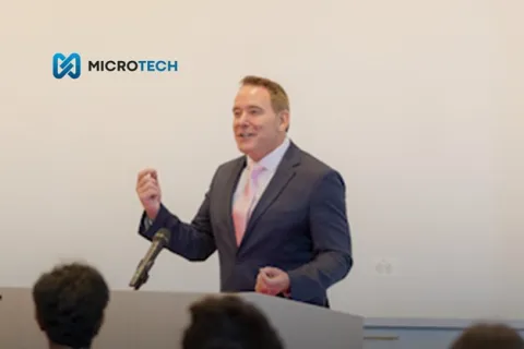 Business professional speaking at a podium with audience and MicroTech logo promoting stronger firm conversations.