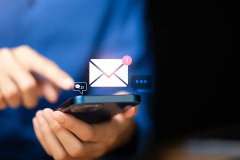 Person using smartphone with digital message and notification icons floating above the device.