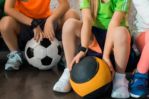 a group of people sitting on a bench with a football ball