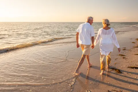 a man and woman walking on a beach