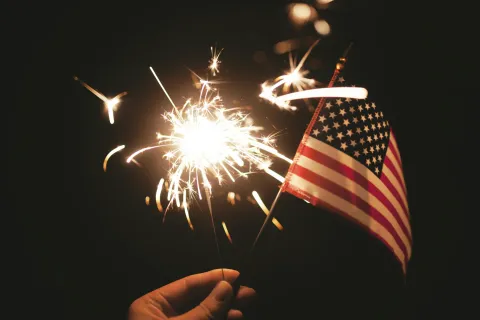 a flag and fireworks in the sky