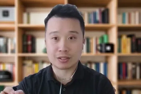 Man speaking with hand gestures in front of a bookshelf during Franchise Champion show with logo in top right corner