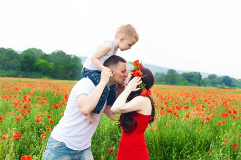 a man and woman kissing in a field of flowers