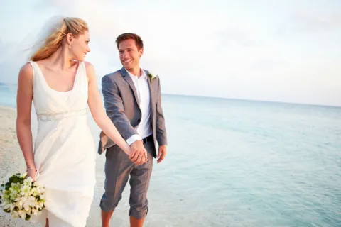 a man and woman holding hands and smiling at the camera