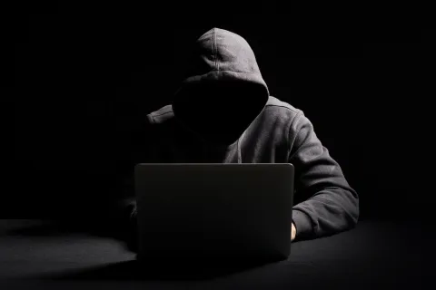 a person sitting on the floor with their head on a laptop