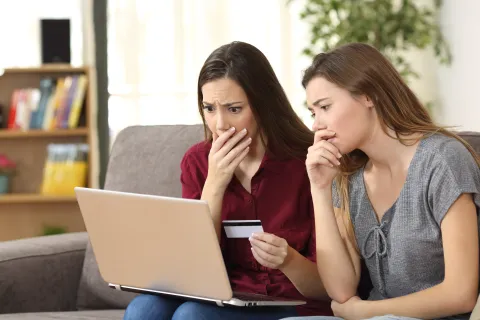 a couple of women looking at a laptop