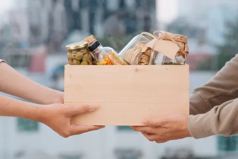 a couple of hands holding a box of donations