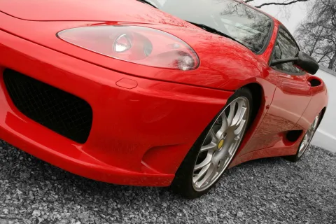 a red car parked on gravel
