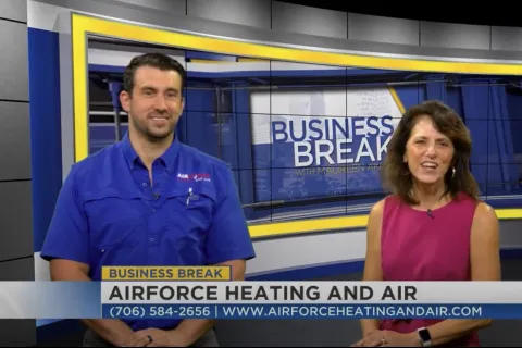 Two hosts in a TV studio promoting Airforce Heating and Air on Business Break show with contact info visible.