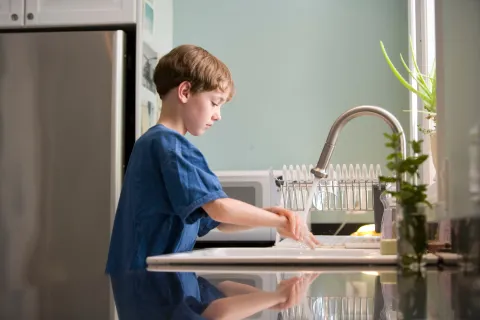 a boy cleaning his sink with baking soda