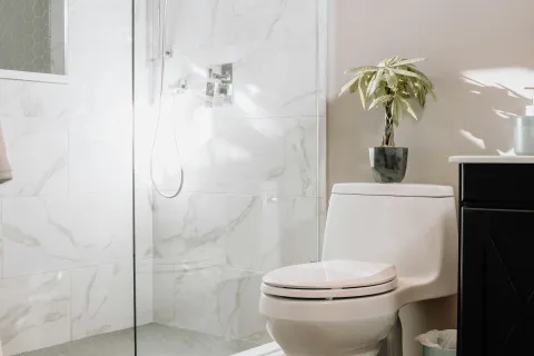a bathroom with a shower unit and toilet