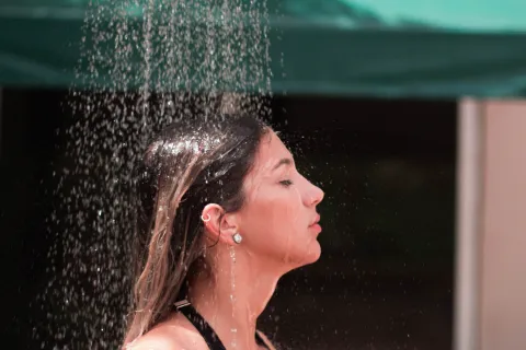 a woman kissing a large water fountain