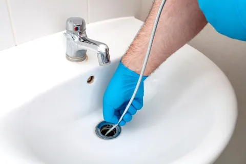 a person using a drain snake