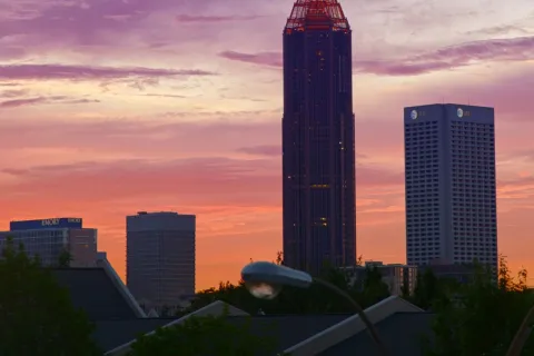 a tall building with a pointy top and a pink and blue sky