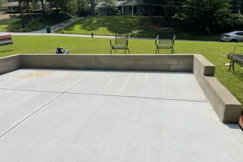 a concrete area with benches and grass