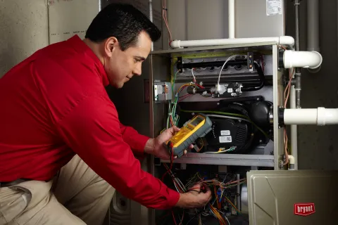 an hvac technician working doing preventative maintenance on an hvac unit