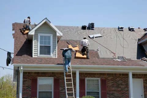 a group of men on top of a house