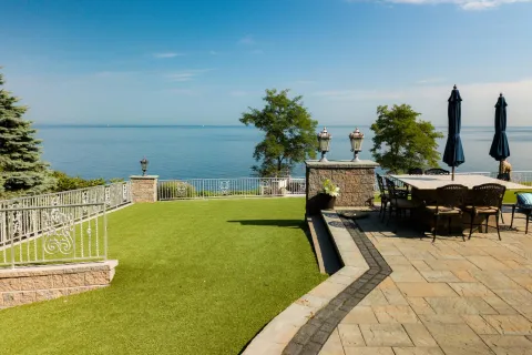 Curved miniature golf course surrounded by olive trees and gravel landscaping on a sunny day