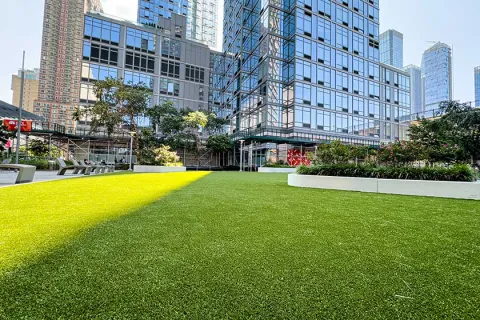a grassy area with buildings in the background