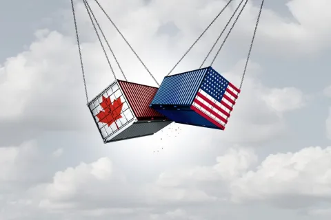 Shipping containers with Canadian and American flags, representing trade and cooperation.