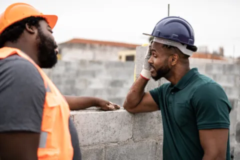 a man with a beard and a man with a hat looking at a building