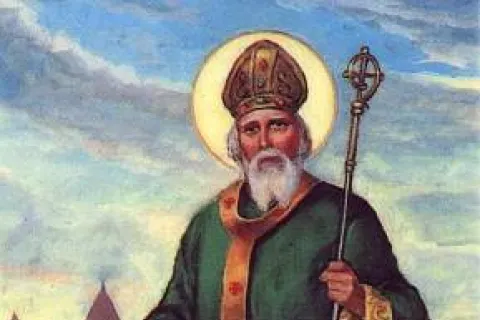 Saint Patrick in bishop's robes with a halo, holding a staff, driving snakes away near a castle.