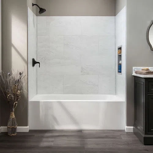 Modern bathroom with white bathtub, large gray tiles, black faucet, and dark vanity with decorative mirror.
