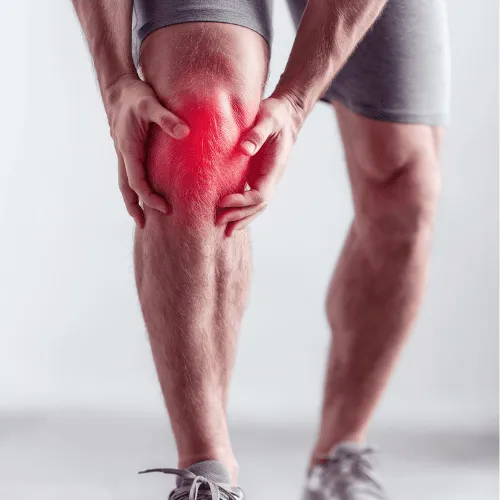 Man holding knee with pain highlighted in red, indicating knee injury or inflammation.