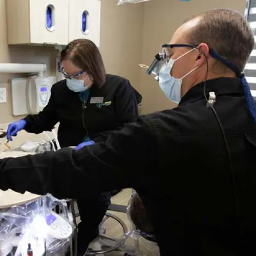 Dental professionals examine X-rays in a modern clinic, focusing on patient care and treatment accuracy.