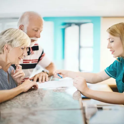 a group of people sitting at a table looking at a paper